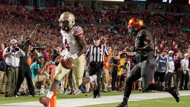 FSU freshman Dalvin Cook completes a 26-yard run to give the Seminoles the go-ahead touchdown with 3:05 remaining against Miami. (Allen Eyestone / The Palm Beach Post)
