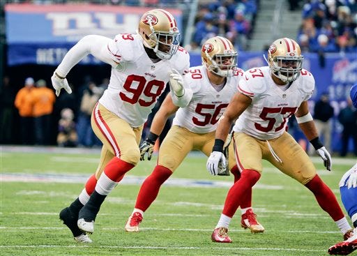 San Francisco 49ers outside linebacker Aldon Smith (99) blitzes as teammates Michael Wilhoite (57) and Chris Borland (50) look on during the first half of an NFL football game against the New York Giants, Sunday, Nov. 16, 2014, in East Rutherford, N.J. The San Francisco 49ers' staff was checked at MetLife Stadium in East Rutherford, New Jersey, after they played the New York Giants.  (AP Photo/Julio Cortez)
