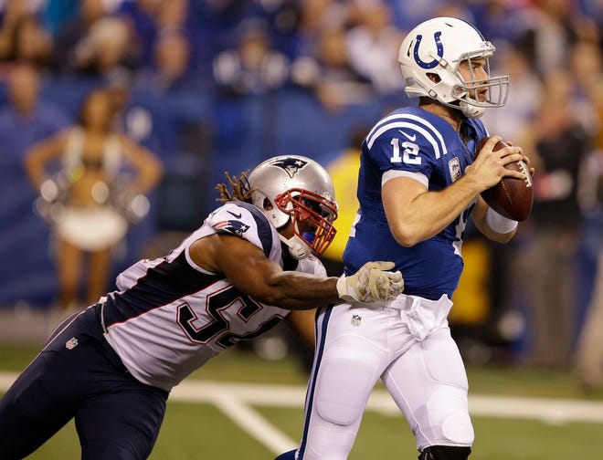 Indianapolis Colts quarterback Andrew Luck looks for a receiver as New England Patriots outside linebacker Dont'a Hightower defends during the first half of an NFL football game in Indianapolis, Sunday, Nov. 16, 2014.