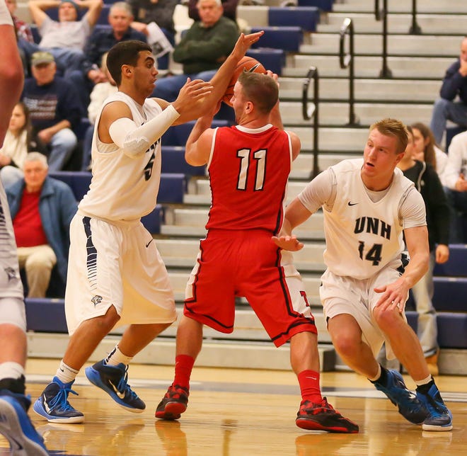 University of New Hampshire players Daniel Dion, left, and John Edwards, right, trap Thomas College's Justin Murray (11) during Tuesday's basketball game at Lundholm Gym in Durham. Photo by Matt Parker.