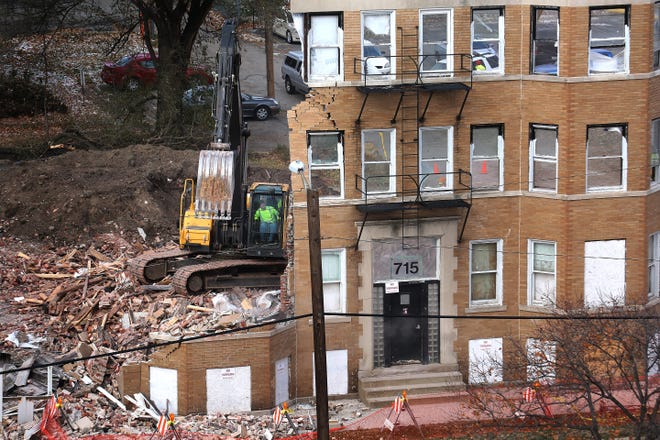 A city employee operating a track excavator takes down the facade of the building, which was the last part standing on Tuesday afternoon. Public Works department employees from the city of Springfield demolished the Knox Flats building at 715 E. Cook St. in Springfield on Tuesday, Nov. 18, 2014. David Spencer/The State Journal-Register