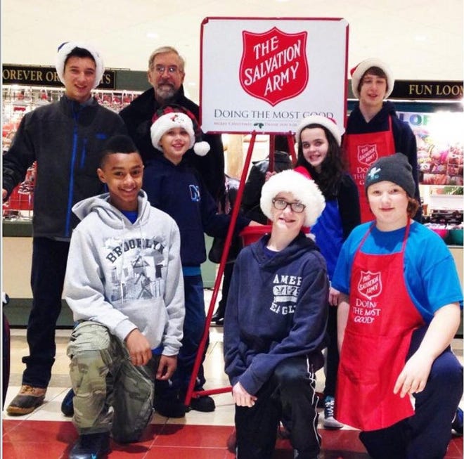 James DelViscio, standing next to the sign without a cap, as chairman of the Newburgh Salvation Army advisory board, welcomes volunteers from the Newburgh Rowing Club and the Goldbacks Youth Football League who will be helping during the holiday season. Photo by Juliana Lobiondo