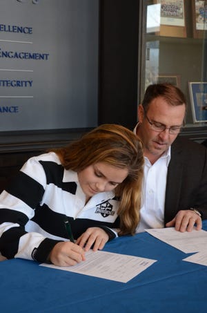 Berwick Academy senior ice hockey player Tilly Burzynski of Rye signs her National Letter of Intent to attend Providence College. At right is her father, Greg. Courtesy photo.