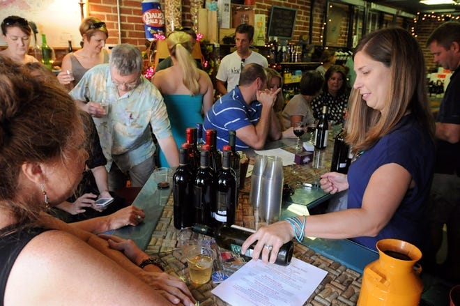 Chrissy Bonney pours a glass of wine for a customer at Wilmington Wine on Castle Street in Wilmington in 2013.