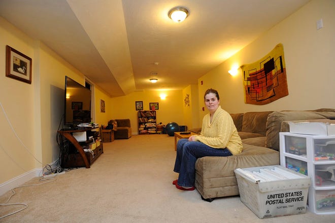 Katherine Wiley, originally from Wellesley, sits in a communal living room space in her group home in Norwood 

(Wicked Local Staff Photo / Brett Crawford)