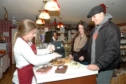 Madeline Weick of Skip’s Candy Corner in Lahaska displays some of the store’s fudge varieties to Mark Berardis and Liz Golden of Cinnaminson, N.J.