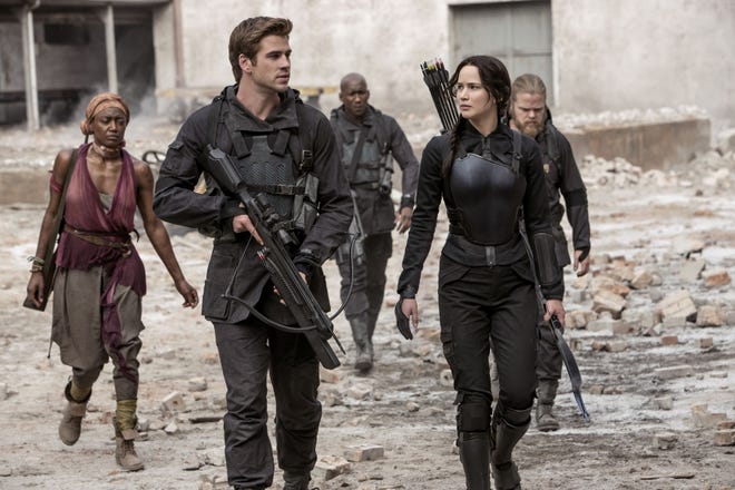 Jennifer Lawrence portrays Katniss Everdeen, right, and Liam Hemsworth portrays Gale Hawthorne in a scene from “The Hunger Games: Mockingjay Part 1.”