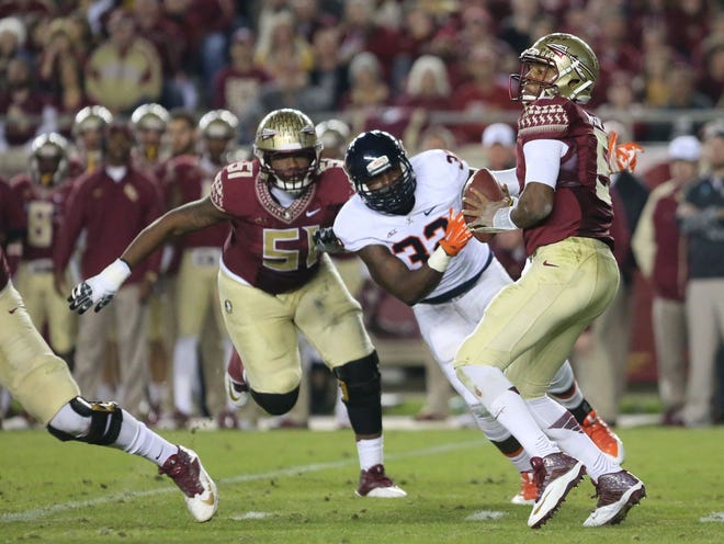 Florida State's Jameis Winston, right, looks for a receiver as he is pressured by Virginia's Mike Moore (32) in the second quarter Nov. 8 in Tallahassee. FSU won 34-20.