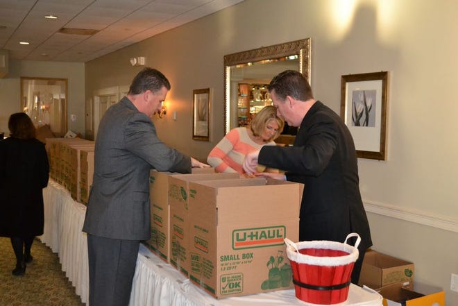 Kevin Segalla, Maura Papile and Keith Segalla of the Quincy Public Schools prepare boxes for distribution to local food pantries. The items were collected at the school department's annual fall party on Thursday, Nov. 20, 2014, at the Tirrell Room in Quincy.