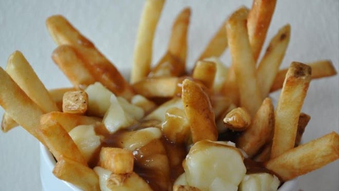 Poutine, a French Canadian street dish, is a heap of fries topped with cheese curds and gravy. (Photo courtesy of Poutine Dog Cafe)
