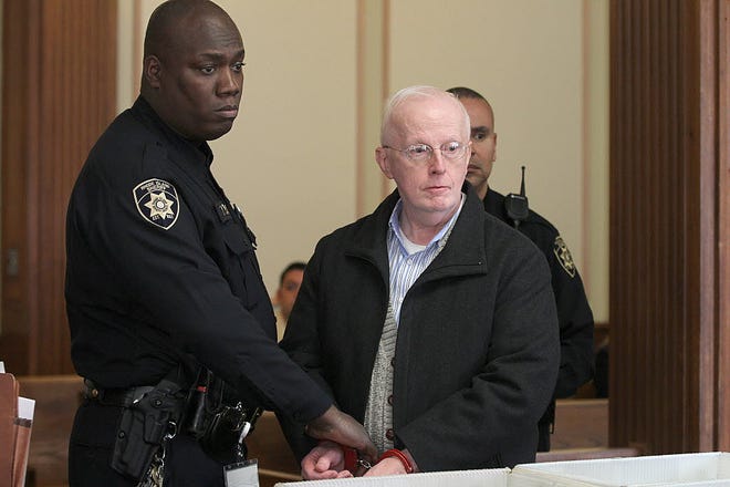 Barry Meehan, a retired priest, stands in Superior Court, Providence, for his arraignment on child molestation charges.