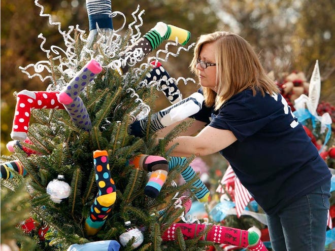Judy Holland decorates the High Socks for Hope tree, one of more than 100 that local businesses, organizations and individuals will prepare for this year's Tinsel Trail. The trail's grand opening begins at 5:30 p.m. Monday. Proceeds benefit Tuscaloosa's One Place.