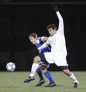 St. John’s Prep senior captain Stephen Heintz of Boxford muscles the ball away from an Acton-Boxborough player last Saturday night in Lynn during the Division 1 North title game. Heintz ended up scoring the game-winning goal in a shootout. Courtesy photo/Ian Richardson