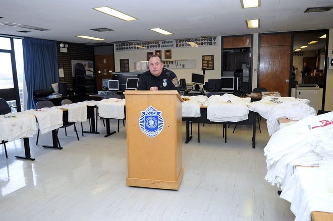 Brockton police code enforcement officer Scott Uhlman is surrounded by hundreds of counterfeit New England Patriots T-shirts he confiscated from the Foxy Lady in Brockton in 2013.