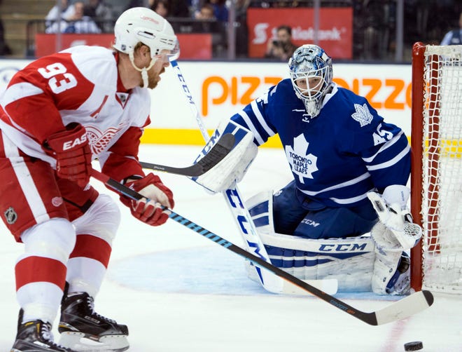Toronto Maple Leafs goaltender Jonathan Bernier defends against Detroit Red Wings' Johan Franzen (93) as he chases the puck during the third period of an NHL hockey game in Toronto on Saturday, Nov. 22, 2014. (AP Photo/The Canadian Press, Frank Gunn)
