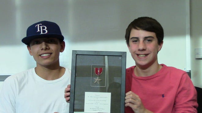 Lenape Middle School students Daniel Clayton and Owen Vrancken pose with the Bronze Star donated to the school by Vietnam Veteran - and Daniel's granduncle - David Horner.
