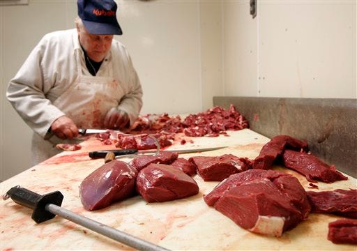 In this photo taken Monday Nov. 17, 2014 veteran meat cutter Everett Gage cuts steaks and roasts from deer following the first weekend of the deer rifle season in Loudon, N.H. Fish and Wildlife officials suspect that interest from local food connoisseurs is helping to level off a drop in the number of hunting license holders nationally, which has been on a steady decline over the last 30 years. AP Photo/Jim Cole