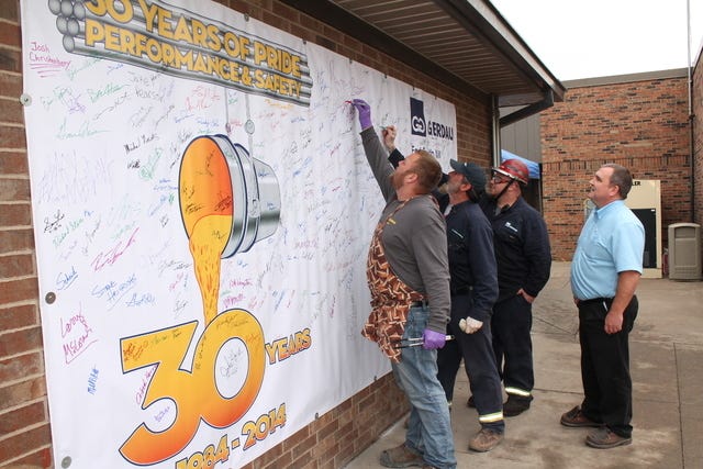 John Lovett • Times Record /
Gerdau team members Prentiss Peters, left, Kevin Beam and Kevin Capocelli sign a 30-year celebration banner Friday, Nov. 21, 2014, during a cookout and luncheon as General Plant Manager Darrel Moore looks on. Construction on the Gerdau Special Steel North America’s Fort Smith Mill began in 1981, and the plant began producing steel in 1984.