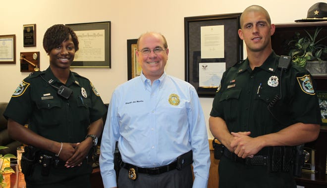 Flagler Sheriff Jim Manfre, center, welcomes new corrections officers Deputy Sheria Murray, left, and Deputy Edward Brienza.