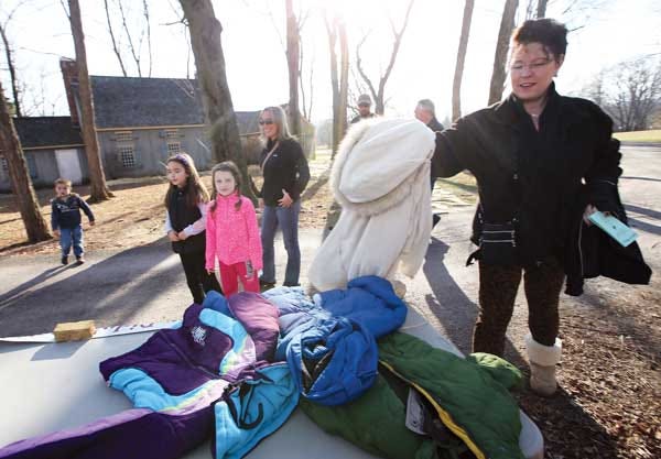 Kim Serocke, of Mount Arilington, drops off a coat at a coat drive table at Waterloo Village in Byram during the village’s Feast on History event on Sunday.