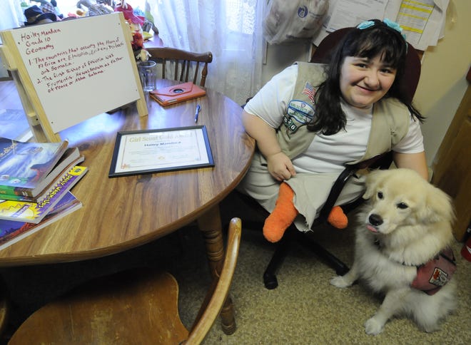 Hailey Manduca, 16, of Bourne, with her service dog, Indy, was born with brittle bone disease. She has earned the Girl Scouts' highest award, the Gold Award, for a video she did about her life and treatment. Merrily Cassidy/Cape Cod Times