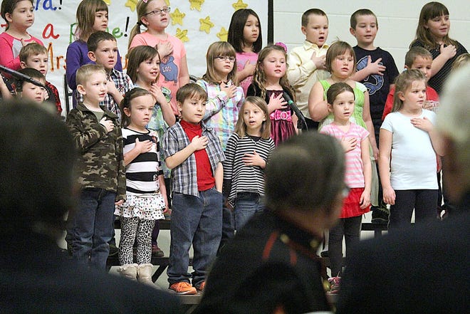 Williams Elementary School first-graders sing "God Bless America" as they salute veterans during a program Thursday morning.