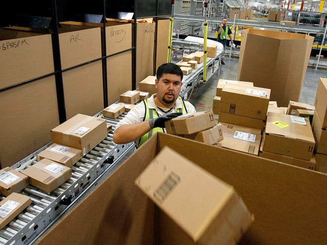 Ricardo Sandoval sorts packages at an Amazon.com fulfillment center on Nov. 11 in Phoenix. Merchants are working hard to make same-day delivery a reality, particularly in major cities, from Amazon testing deliveries via taxis to everyone from Target to Google expanding their same-day delivery services.