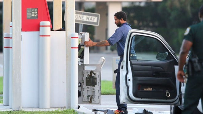 A technician works on an ATM at the Bank of America at 7281 Lake Worth Road Monday morning, November 24, 2014 after 2 men tried to steal the machine overnight. (Lannis Waters/The Palm Beach Post)