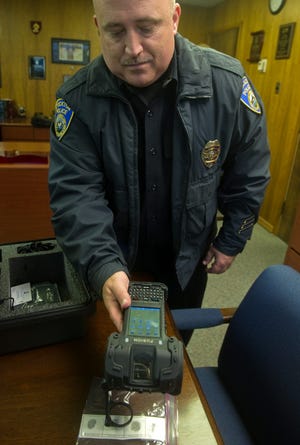 Stockton Police public information officer Joseph Silva demonstrates the department's new fingerprint scanning device. CLIFFORD OTO/THE RECORD