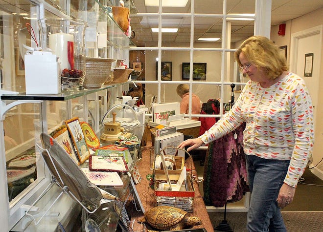 Artist and Artisan Shop volunteer Carol Duffy, of Plymouth, looks over the items for sale, including her own fabric art. Photo courtesy of Pamela Tibbetts