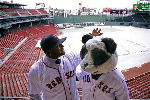 Newly acquired Boston Red Sox free agent third baseman Pablo Sandoval, nicknamed Kung Fu Panda, converses with a person dressed as a panda bear wearing a Red Sox jersey, overlooking a tarp covered Fenway Park field on Tuesday. AP photo
