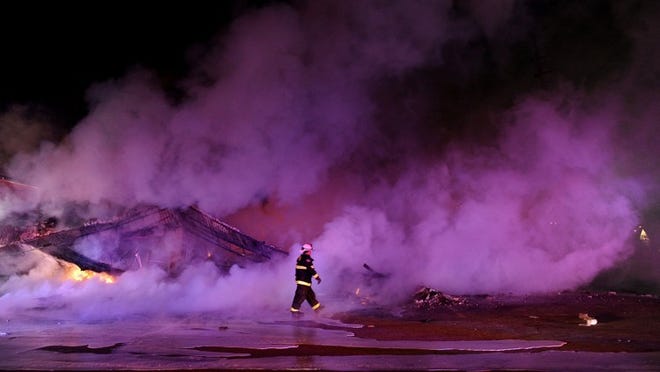A firefighter walks by a burned strip mall at Chambers Road and West Florissant Avenue on Monday, after the Ferguson grand jury decision was announced. (Wally Skalij/Los Angeles Times/TNS)