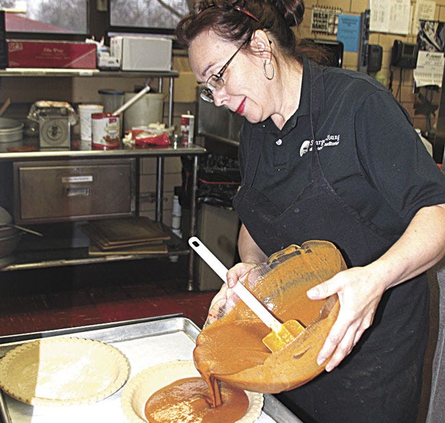 Sturges-Young Auditorium staff member Becky Evilsizor works on pumpkin pies in preparation for a Thanksgiving feast. Evilsizor has been using her grandmother's recipe at the auditorium for years.