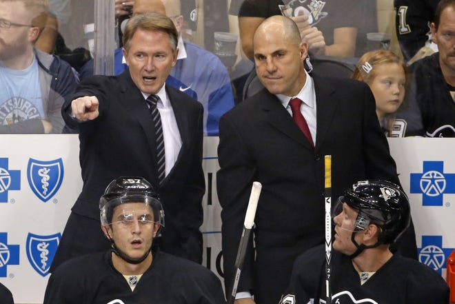 Pittsburgh Penguins head coach Mike Johnston, left, sets up a power play with assistant Rick Tocchet in the first period of a NHL pre-season hockey game in Pittsburgh Thursday, Sept. 25, 2014. (AP Photo/Gene J. Puskar)