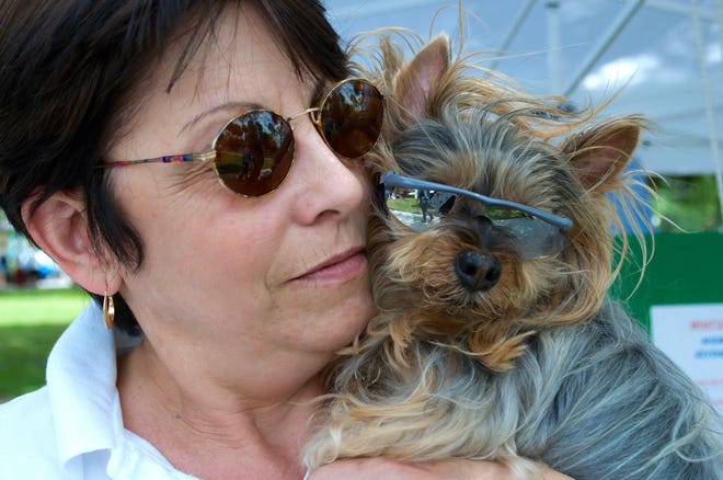 Psychic medium Eden Cross with Saki, her Yorkie, snuggle during a recent community event. Cross donates a portion of the proceeds from her readings to local pet rescue organizations.
