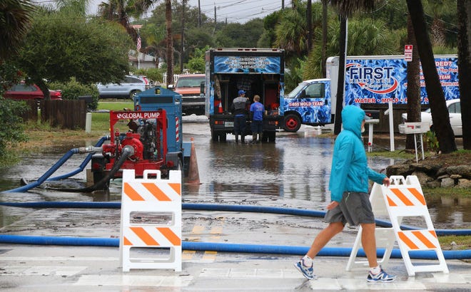 Pumps carry away some of the lingering flood waters on Columbus Ave. in New Smyrna Beach Wednesday.