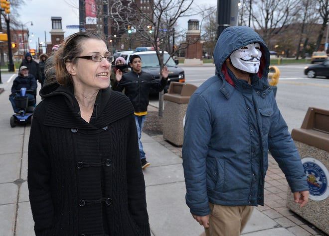 Heather Garczynski, 44, at left, and Deonte Owens, 20, both of Erie, march and chant Nov. 25 in front of Erie City hall in downtown Erie. They and seven other local activists were protesting the decision by the grand jury in Ferguson, Mo. not to charge a Ferguson police officer Darren Wilson with the shooting death of an unarmed Michael Brown in August. Owens said he wore a mask because he is loosely affiliated with Anonymous, an international group of online and offline activists. CHRISTOPHER MILLETTE/