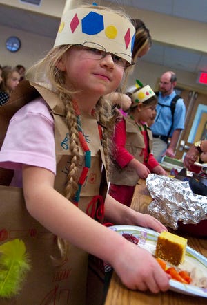 Kerri Davis, 6, gets a plate of turkey and fixings during Woodman Park School's annual Thanksgiving feast Tuesday.