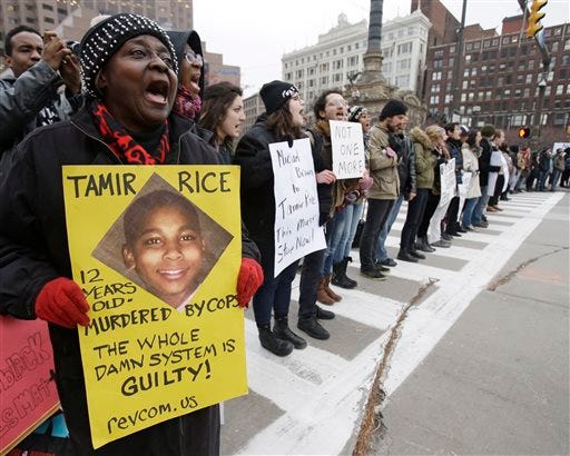 Demonstrators block Public Square Tuesday, Nov. 25, 2014, in Cleveland, during a protest over the weekend police shooting of Tamir Rice. The 12-year-old was fatally shot by a Cleveland police officer Saturday after he reportedly pulled a replica gun at the city park. (AP Photo/Tony Dejak)