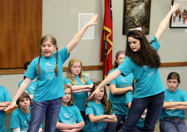 Jamie Mitchell • Times Record - Tiger Lilly, played by Dana Mays, left, and Wendy, played by Gabrielle Gore, lead the Indians in song Tuesday, Nov. 25, 2014, during the University of Arkansas at Fort Smith's Academy of Arts Playerz special preview of "Peter Pan Jr.," in the community room of the Main Library. The play will be staged at 2 and 7 p.m. on Dec. 13, and 2 p.m on Dec. 14 at Breedlove Auditorium.
