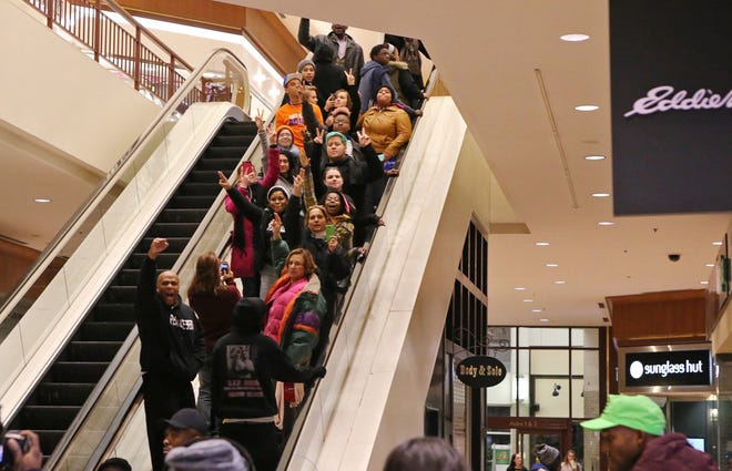 Twenty to thirty protesters marched through the St. Louis Galleria on Wednesday, Nov. 26, 2014, chanting slogans. They stayed in the mall for about fifteen minutes and then left peacefully without confrontation with a large police presence. (J.B. Forbes/St. Louis Post-Dispatch/TNS)