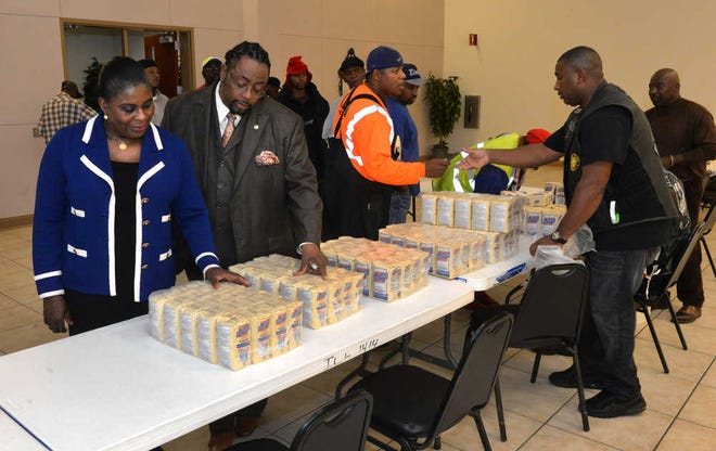 Steve Bisson/Savannah Morning NewsAt-large city alderman Carolyn Bell and International Longshoreman Association Local 114 president Thomas Stokes III look at packages of Dixie Crystal Sugar along with gift cards being given away at Thanksgiving at the ILA building on East Lathrop Avenue.