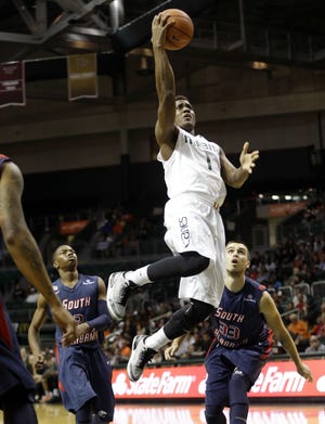 Miami guard Deandre Burnett (1) shoots during the first half of Friday’s game against South Alabama.