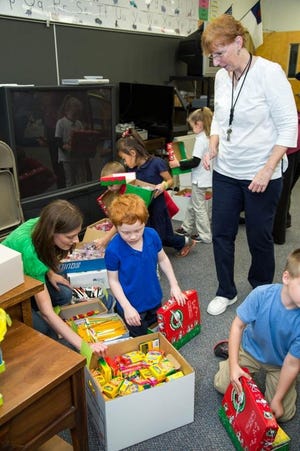 Kindergarten class with teacher Donna Febbo help fill shoeboxes for Operation Christmas Child.