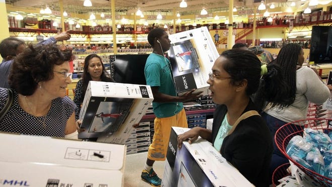 Ginger Kennedy, (L), and Famina Chawdhury, (R), both of West Palm Beach join customers at Brandsmart picking up 32 inch Sony TV on sale for $99.00 during the start of Thanksgiving Day shopping Nov 27, 2014 in West Palm Beach. Close to three hundred customers where in line at the West Palm Beach store before the doors open at 4:00PM. (Bill Ingram / Palm Beach Post)Beach Post)