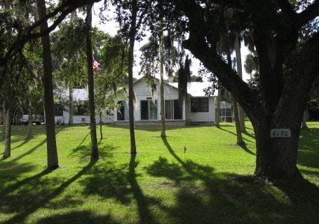 This house for sale among the oaks and pines at 6170 Harbor Road near Port Orange sits on 2.2 acres along Rose Bay and includes two cottages.