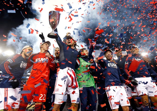 Confetti falls as New England Revolution's Jermaine Jones holds the MLS Eastern Conference Champion's Cup aloft with teammates after their second soccer game against the New York Red Bulls in Foxborough, Mass., on Saturday. The match ended 2-2 and New England advanced to the MLS Cup with a two-game aggregate score of 4-3. AP Photo