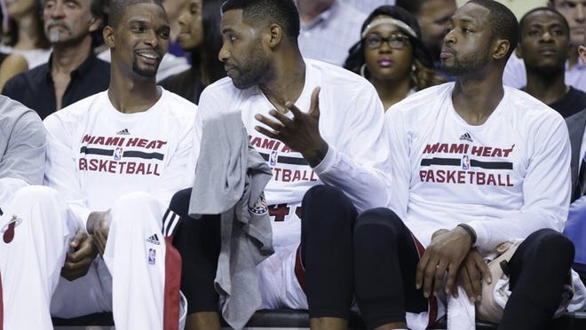 Miami forward Shawne Williams sits on the bench between Chris Bosh, left, and Dwyane Wade. Williams has been a key contributor because of his 3-point shooting. (AP Photo/Lynne Sladky)