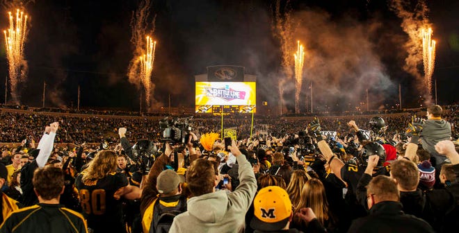 Missouri fans rush the field and celebrate after the team's 21-14 victory over Arkansas in an NCAA college football game Friday, Nov. 28, 2014, in Columbia, Mo. Missouri won 21-14. (AP Photo/L.G. Patterson)