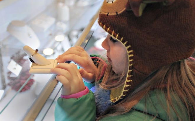 Julia Roman,5, admires her birthstone while shopping at The Newtown Jewelers during Small Business shopping day on Saturday.